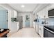 Bright kitchen with stainless steel appliances, white cabinets, light countertops, and a blue back door at 7137 Bougenville Dr, Port Richey, FL 34668