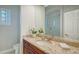 Bathroom with granite counters, a decorative mirror, and a glass-enclosed shower at 7340 Barclay Ct, University Park, FL 34201