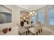 Elegant dining room featuring a glass-top table, stylish chairs, and a sophisticated chandelier at 7340 Barclay Ct, University Park, FL 34201