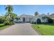 Beautifully landscaped home featuring a tile roof, brick driveway, and lush tropical landscaping at 7340 Barclay Ct, University Park, FL 34201