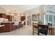 Open kitchen and dining area with dark wood cabinetry, an island with seating, and a modern chandelier at 7340 Barclay Ct, University Park, FL 34201