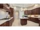 Bright kitchen with dark wood cabinetry, white countertops, tile flooring, and stainless appliances at 7340 Barclay Ct, University Park, FL 34201