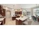 Well-lit kitchen with a center island, dark wood cabinets, and views into the dining area at 7340 Barclay Ct, University Park, FL 34201
