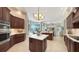 Bright kitchen with dark wood cabinets, white countertops, and an island, opening to the living room at 7340 Barclay Ct, University Park, FL 34201