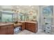Main bath with dual sinks, granite countertops, cherry cabinets, recessed lights, and a decorative mirror at 7340 Barclay Ct, University Park, FL 34201