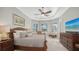 Comfortable main bedroom features a ceiling fan, bay window, neutral color palette and dark wood furnishings at 7340 Barclay Ct, University Park, FL 34201