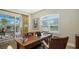 Bright office with a large wood desk, piano, and sliding door to the outdoor pool area at 7340 Barclay Ct, University Park, FL 34201