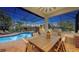 Covered and screened patio area featuring a dining table, grill, and scenic views of the pool and backyard at 7340 Barclay Ct, University Park, FL 34201