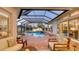 Relaxing screened-in pool area with comfortable seating and ambient lighting at dusk at 7340 Barclay Ct, University Park, FL 34201
