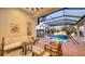 Covered patio with comfortable seating overlooking a sparkling pool and manicured landscaping at 7340 Barclay Ct, University Park, FL 34201