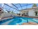 Stunning pool and spa with blue tile accents in screened-in patio area surrounded by lush landscaping at 7340 Barclay Ct, University Park, FL 34201