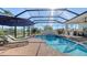 Relaxing screened-in pool area with spa, lounge chairs and a view of the lake at 7340 Barclay Ct, University Park, FL 34201