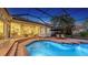 A screened in-ground pool and spa with an outdoor living area and lush landscaping at 7340 Barclay Ct, University Park, FL 34201