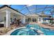 Gorgeous screened pool with a brick patio, perfect for relaxing and entertaining outdoors with a spa and patio furniture at 7340 Barclay Ct, University Park, FL 34201