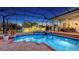 Backyard pool and spa with patio and outdoor kitchen covered by screened-in enclosure at twilight at 7340 Barclay Ct, University Park, FL 34201
