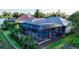 A screened-in pool is surrounded by palms and lush landscaping at 7340 Barclay Ct, University Park, FL 34201