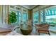 Bright sunroom sitting area with stylish chairs and a lovely view of the community at 7340 Barclay Ct, University Park, FL 34201