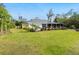 A nicely landscaped yard features a covered patio with chairs in the backyard of this home at 749 Tropical Cir, Sarasota, FL 34242