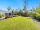 Spacious backyard with lush lawn, mature landscaping, and screened-in porch at 749 Tropical Cir, Sarasota, FL 34242
