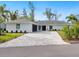 Charming single-story home with a paver driveway and manicured landscaping at 749 Tropical Cir, Sarasota, FL 34242