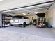 View of a spacious three car garage with epoxy floors and vehicles at 749 Tropical Cir, Sarasota, FL 34242