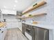 Bright kitchen featuring white cabinets, stainless appliances, wood countertops, and floating wood shelves at 749 Tropical Cir, Sarasota, FL 34242