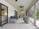 Covered patio featuring wicker furniture, ceiling fans, and outdoor seating area at 749 Tropical Cir, Sarasota, FL 34242