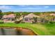 Backyard view featuring a screened lanai overlooking the lush green space and pond at 7655 Pesaro Dr, Sarasota, FL 34238