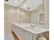 Bright bathroom featuring double sinks with white cabinetry and a large mirror at 7655 Pesaro Dr, Sarasota, FL 34238