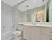 Clean bathroom with a tub, toilet, and vanity with white cabinets at 7655 Pesaro Dr, Sarasota, FL 34238