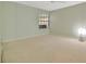 Neutral bedroom with carpet, a window, and a decorative lamp at 7655 Pesaro Dr, Sarasota, FL 34238