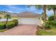 View of the home's brick driveway with tropical landscaping at 7655 Pesaro Dr, Sarasota, FL 34238