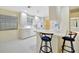 Bright, all-white kitchen with bar seating, stainless steel appliances, and plenty of natural light from the window at 7655 Pesaro Dr, Sarasota, FL 34238