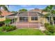 The screened-in lanai has brick flooring and overlooks lush landscaping at 7655 Pesaro Dr, Sarasota, FL 34238