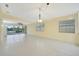 Bright and airy living room featuring large windows, neutral tones, and tile flooring, perfect for modern living at 7655 Pesaro Dr, Sarasota, FL 34238
