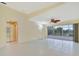 Bright living room with tile floors, ceiling fan, and sliding glass doors to the patio at 7655 Pesaro Dr, Sarasota, FL 34238