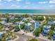 Stunning aerial view of a coastal home near a pristine beach and turquoise waters, surrounded by lush tropical greenery at 785 Jacaranda Rd, Anna Maria, FL 34216