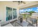 Relaxing screened-in balcony featuring cozy seating and views of the surrounding neighborhood and lush greenery at 785 Jacaranda Rd, Anna Maria, FL 34216
