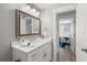 Clean and modern bathroom with a single sink vanity, neutral tones, and a glimpse into an adjacent bedroom at 785 Jacaranda Rd, Anna Maria, FL 34216