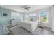 Bright bedroom with a coastal theme, complemented by wood floors and plenty of natural light from multiple windows at 785 Jacaranda Rd, Anna Maria, FL 34216