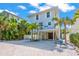 Charming two-story beach house with white picket fence and lush tropical landscaping at 785 Jacaranda Rd, Anna Maria, FL 34216