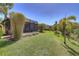 Beautiful backyard featuring lush green lawn and tropical landscaping with palm trees at 8168 36Th E St, Sarasota, FL 34243