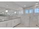 Modern bathroom featuring white marble tile, dual sinks, and a glass enclosed shower with natural light at 8207 Nevis Run, Bradenton, FL 34202