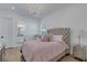 Comfortable bedroom featuring a chandelier, tufted headboard, and wood look tile floors at 8207 Nevis Run, Bradenton, FL 34202