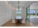 Elegant dining room with modern chandelier, wood floors, and access to the outdoor pool area at 8207 Nevis Run, Bradenton, FL 34202