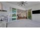 A kitchen with white cabinets, an island, and stainless steel appliances, viewed from the outdoor kitchen at 8207 Nevis Run, Bradenton, FL 34202