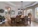 Formal dining room featuring hardwood floors, stylish lighting, and a large window for natural light at 8227 37Th Avenue W Cir, Bradenton, FL 34209