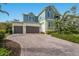 Inviting two-story home featuring a brick driveway and a two-car garage, complemented by lush landscaping at 8227 37Th Avenue W Cir, Bradenton, FL 34209