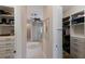Hallway view of ensuite bath and large walk-in closet with custom shelving and storage space at 8227 37Th Avenue W Cir, Bradenton, FL 34209
