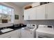 Well-equipped laundry room with sink, storage cabinets, and modern appliances at 8227 37Th Avenue W Cir, Bradenton, FL 34209